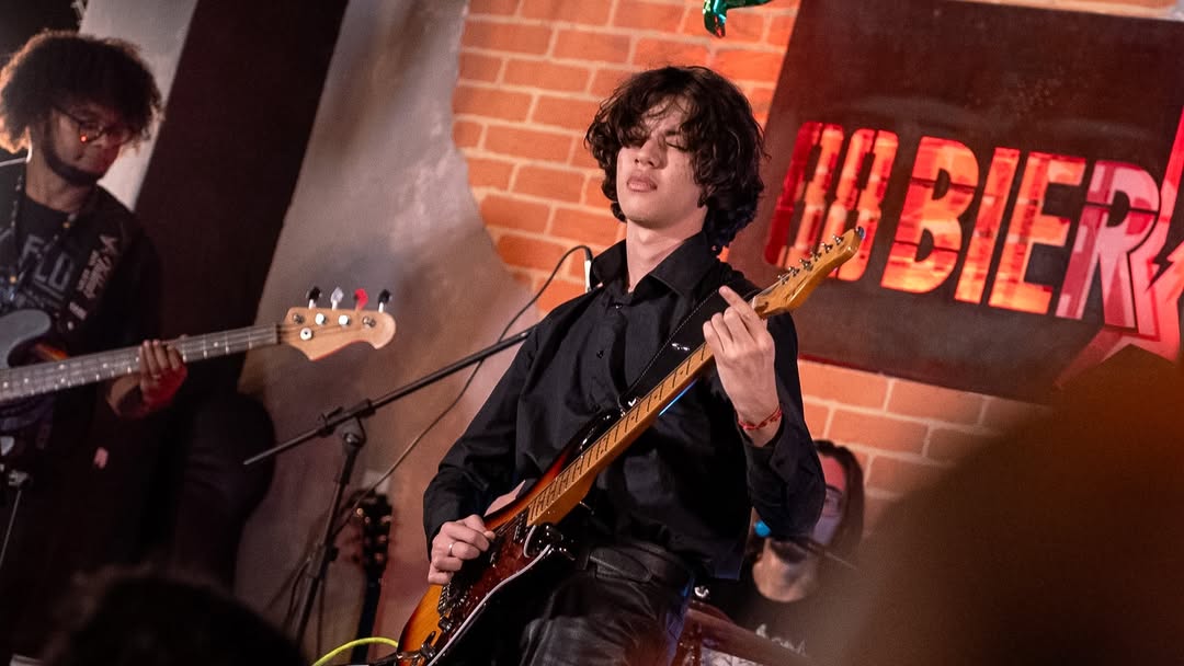 Aluno tocando guitarra em apresentação da Ponto Musical