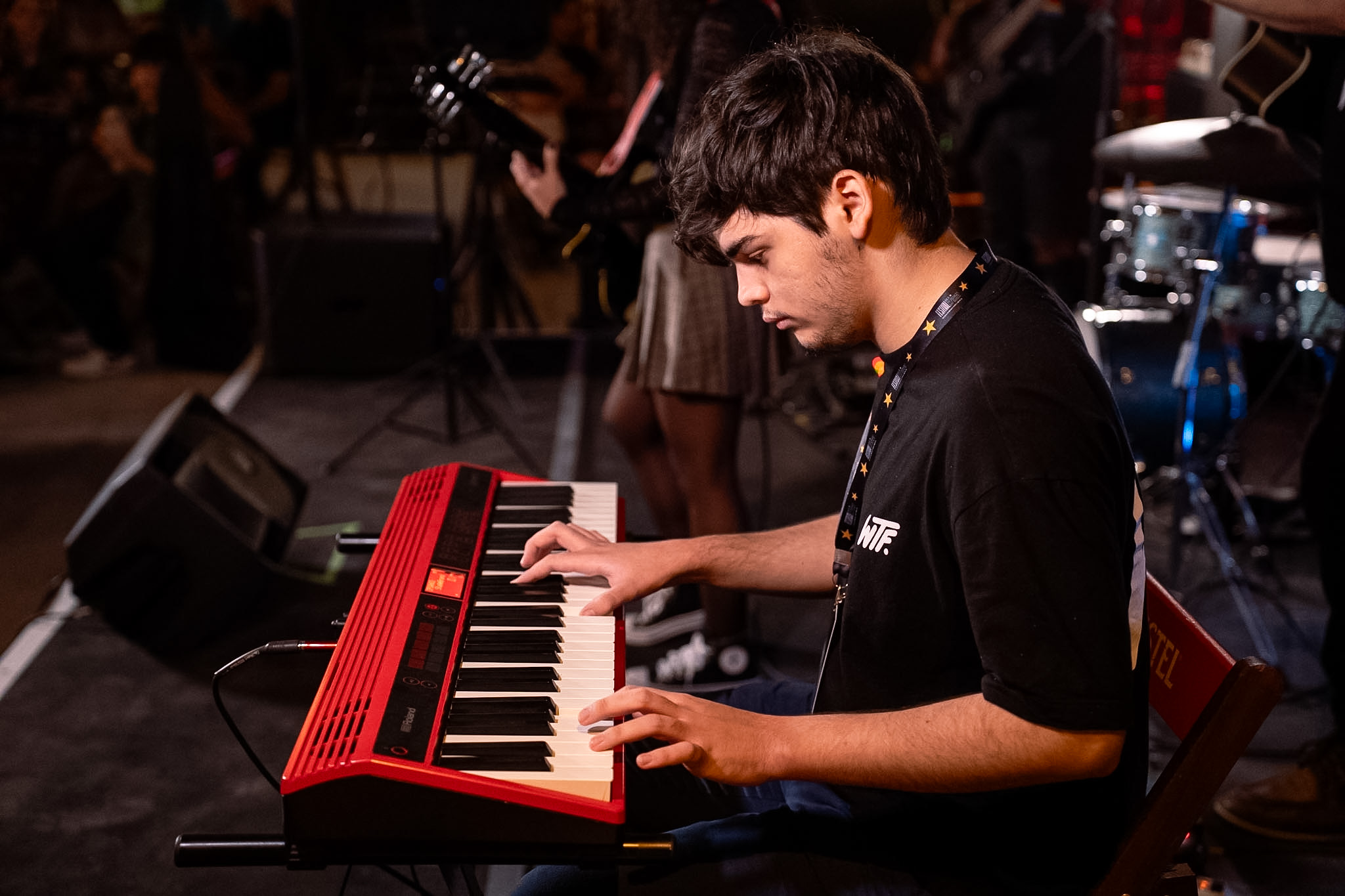 Aluno tocando teclado em apresentação da Ponto Musical